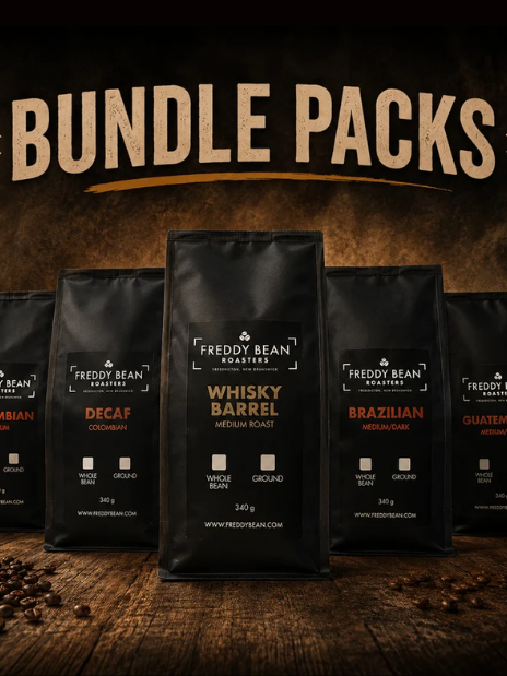 Bundle Packs promo art with five bags fanned across a wooden table, Whisky Barrel in front, loose beans scattered